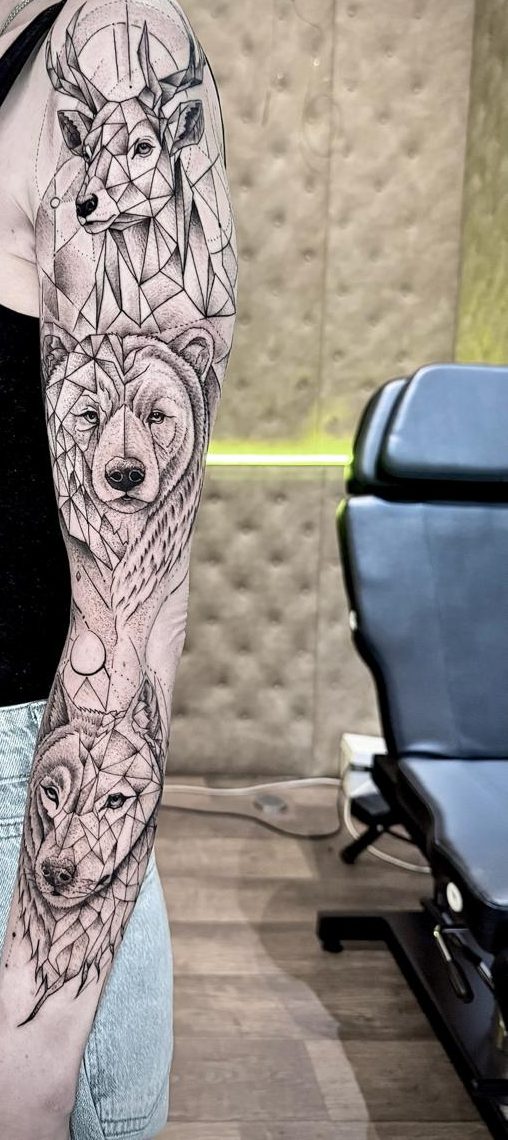 Bras complet géométrique en dotwork : cerf, ours et loup faits de facettes et de points, par Kako Tattoo à Genève