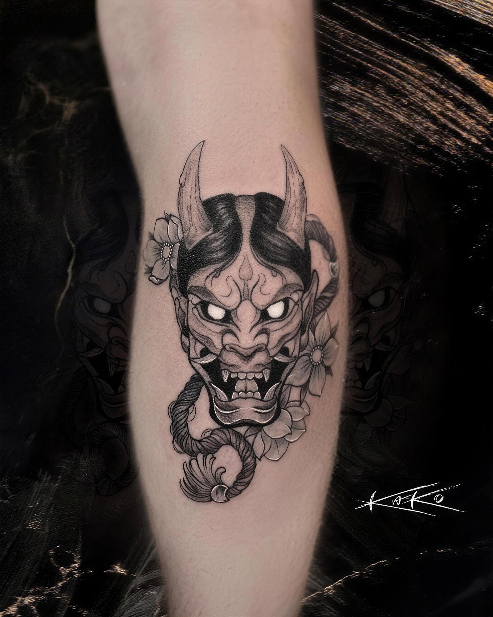 Masque hannya japonais en noir et gris sur le mollet, par Kako Tattoo à Genève