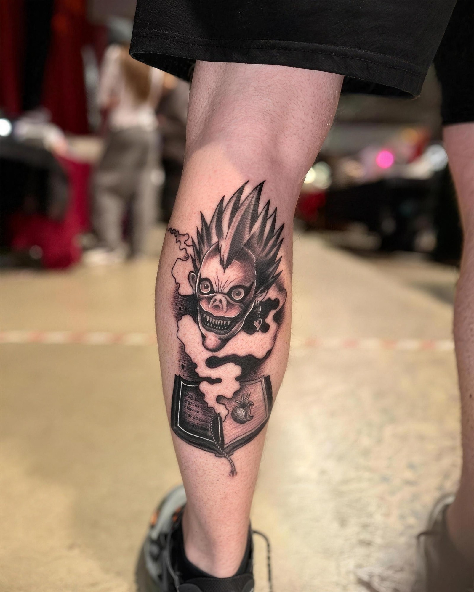 Ryuk de Death Note en noir et gris sur le mollet, par Kako Tattoo à Genève